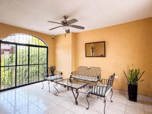 a living room with a ceiling fan and a table and chairs at Hotel Santa Ana in Valladolid