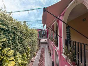 an alley between two buildings with a pink building at Hotel Santa Ana in Valladolid