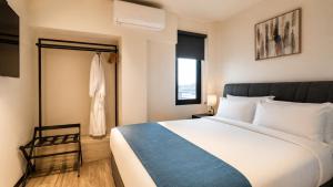 a bedroom with a large bed and a window at Grand Resort & Residences in Belize City