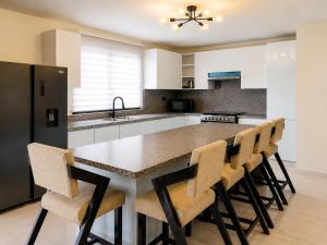 a kitchen with a large island with bar stools at Skylight Suites Hotel in San Felipe de Puerto Plata