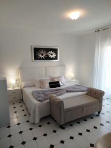 a white bedroom with a large bed and a couch at Pension Fercomar in Sanxenxo