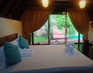 a bedroom with a bed with elephant towels on it at Dambulla Tiger Rock Hotel with Mountain Viewpoint in Dambulla