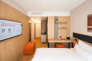 a hotel room with a bed and a projection screen at Tailormade Hotel METROPOL St Gallen in St. Gallen