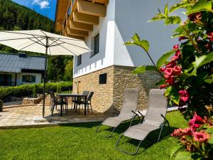 a patio with a table and chairs and an umbrella at Rupertichalet in Zell am See
