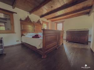 a bedroom with a large wooden bed and a dresser at Casetta dalle finestre rosse in Bedonia
