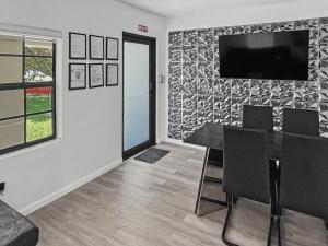 a dining room with a table and a television on a wall at Casa Arya in Howard +2 photos