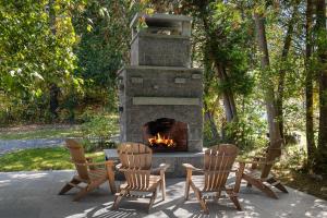 a fireplace with three chairs and a fire place at Stowestruck in Stowe