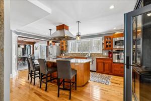 a kitchen with wooden cabinets and a bar with chairs at Stowestruck in Stowe