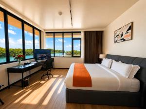 a bedroom with a bed and a desk with a computer at Grand Resort & Residences in Belize City