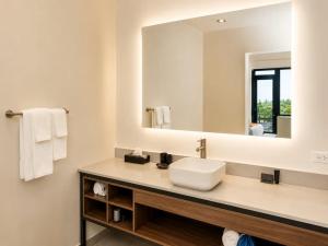 a bathroom with a sink and a mirror at Grand Resort & Residences in Belize City