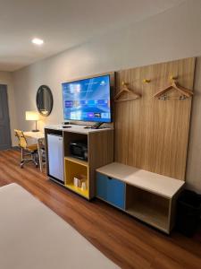 a room with a flat screen tv on a stand with a table at Days Inn by Wyndham Payson in Payson