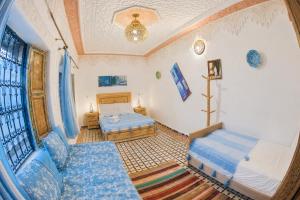 a bedroom with two beds and a couch and a window at Riad Chada Fez in Fez