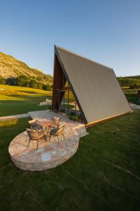 a building with a table and chairs in a field at Falcon View Zabljak in Žabljak +7 photos