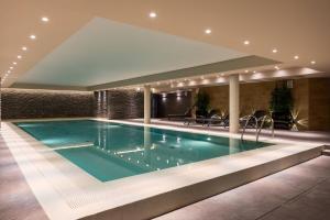 a swimming pool in a building with a swimming poolvisor at AC Hotel by Marriott Wroclaw in Wrocław