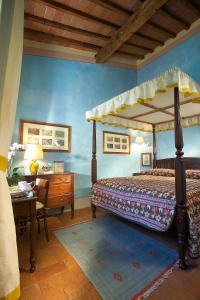 フィレンツェにあるアンティカ ディモーレ フィレンツェのベッドルーム1室(天蓋付きベッド1台、デスク、テーブルシックスシックス付)