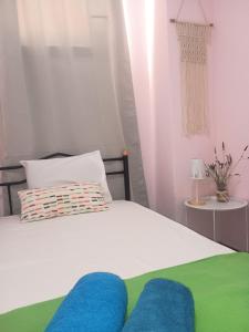 ein Schlafzimmer mit einem weißen Bett mit blau-grüner Bettwäsche in der Unterkunft Trizinia View in Galatás