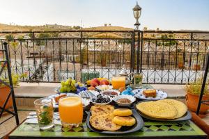 a breakfast table with food and orange juice on a balcony at Riad Chada Fez in Fez