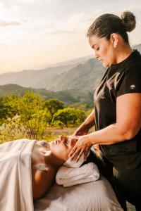 a woman sitting on a bed with a man touching her face at Lakay Monteverde with Heated Pool, Golf Cart, Breakfast in Monteverde Costa Rica