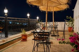 a group of tables and chairs with umbrellas on a balcony at Riad Chada Fez in Fez