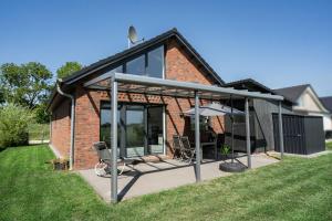 an extension to a brick house with a patio at Haus Weitwinkel in Sehestedt