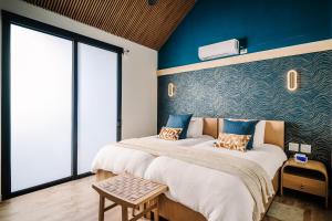 two beds in a room with blue walls at Lakay Monteverde with Heated Pool, Golf Cart, Breakfast in Monteverde Costa Rica