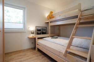 a bedroom with two bunk beds and a window at Haus Weitwinkel in Sehestedt
