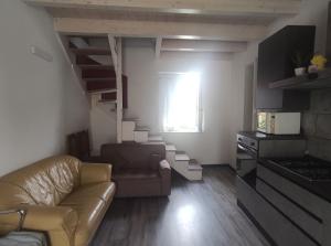 a living room with a couch and a spiral staircase at Sweet Home in Corbetta