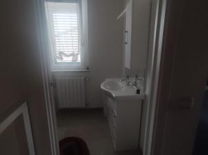 a white bathroom with a sink and a window at Sweet Home in Corbetta