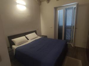 a bedroom with a blue bed and a window at Sweet Home in Corbetta