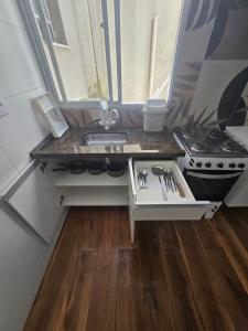 a small kitchen with a sink and a stove at Apartamento quarto e sala em campo grande in Cariacica