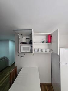 a small kitchen with a microwave and a table at Apartamento quarto e sala em campo grande in Cariacica