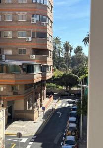 a building and a street with cars parked next to it at Hernández Central Park in Melilla