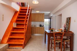 a kitchen with a wooden staircase next to a dining room table at Linas Concept in Fourfourás
