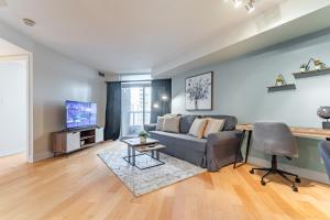 a living room with a couch and a tv at Designer Apartment in Prime Location in Mississauga