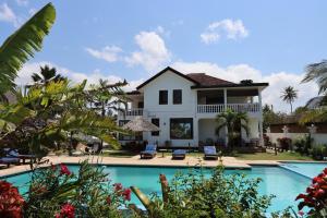 a villa with a swimming pool and a house at Villa Dahl Beach Resort in Dar es Salaam