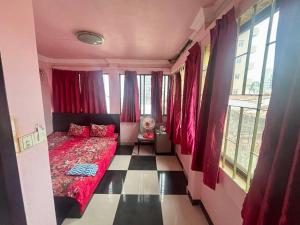 a bedroom with a red bed in a room with windows at Arecrata in Phnom Penh