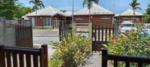 a gate to a house with a fence at 36 Baltazia, 2 Ch 2 Pers-Clim jardin terrasse à Sainte-Anne in Sainte-Anne