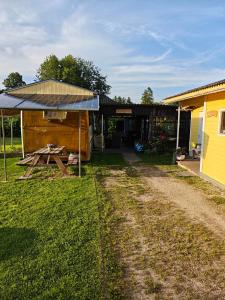 a house with a solar roof next to a dirt road at Glampingbus in Kärdla