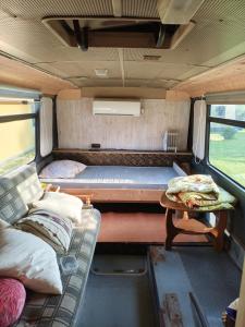 a small room with a bed and a table in it at Glampingbus in Kärdla