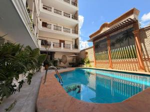 a swimming pool in front of a building at Hotel Residencial in Mérida