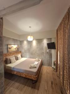 a bedroom with a large bed and a television at IL TRAMONTO APARTMENT 1 in Kanali