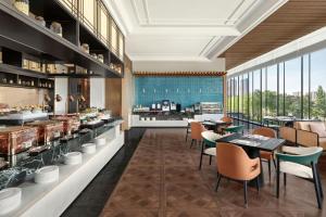 a rendering of a restaurant with tables and chairs at Fairfield by Marriott Yulin in Yulin +24 photos