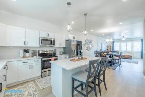 a kitchen with white cabinets and a kitchen island with chairs at Pooley Pad in American Fork