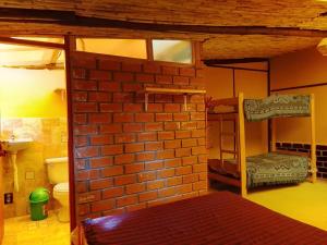 a room with two bunk beds and a brick wall at Tony's House Eco Hostel in Huaraz