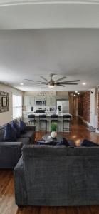 a living room with two couches and a ceiling fan at Xscapecation Oasis III in Tulsa