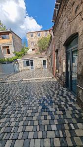 a cobblestone street in front of a stone building at Jivani 105 in Gyumri
