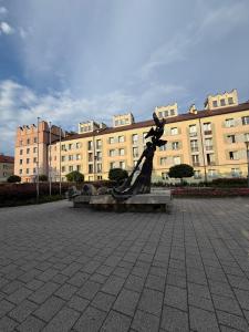 a statue of a woman sitting on a bench in front of a building at Apartament Witosa in Tarnów