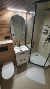 a bathroom with a toilet and a sink and a shower at Apartament Witosa in Tarnów +18 photos