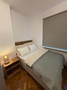 a small bedroom with a bed and a side table at Apartament Witosa in Tarnów