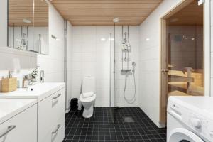 a bathroom with a shower and a toilet and a sink at Wallesmanni - Nokia Arena by Come in! in Tampere +75 photos